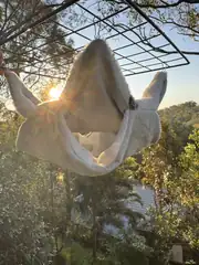 Oddball-made hanging hide hammock suspended outdoors, showing its sheltered shape.